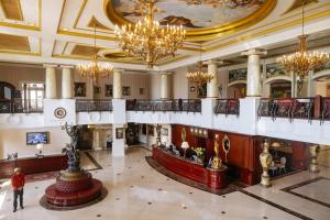 a large lobby with chandeliers and a person walking in a building at The IMPERIAL Vung Tau Hotel in Vung Tau