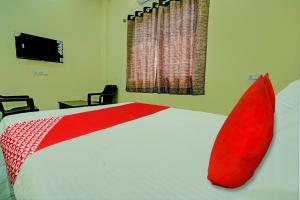 Un dormitorio con una cama grande con almohadas rojas. en Hotel O Bliss Inn, en Rāipur