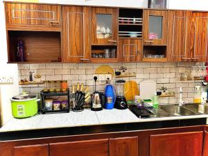 a kitchen with wooden cabinets and a counter top at Serenity Stay in Nikawatawana