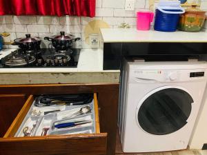 a kitchen with a stove and a washing machine at Serenity Stay in Nikawatawana