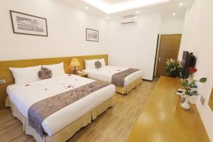 Postel nebo postele na pokoji v ubytování Family Hanoi Hotel