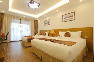 Postel nebo postele na pokoji v ubytování Family Hanoi Hotel