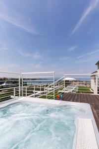 einen Whirlpool auf einer Terrasse mit Meerblick im Hintergrund in der Unterkunft Hotel Acquadolce in Peschiera del Garda