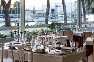 una sala da pranzo con tavolo e bicchieri di Hotel Acquadolce a Peschiera del Garda