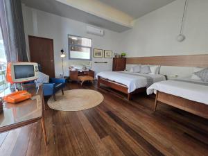 a hotel room with two beds and a television at haus50s hometel in Hat Yai