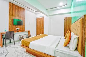 a bedroom with a bed and a desk and a television at FabHotel New 7 Star in Mumbai