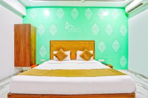 a bedroom with a large bed with a green wall at FabHotel New 7 Star in Mumbai