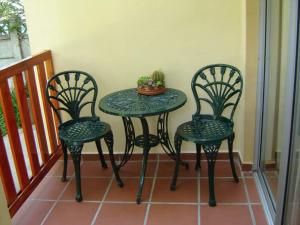 ein Tisch und zwei Stühle und ein Tisch mit einer Pflanze darauf in der Unterkunft Cedar Lodge Guest House in Robertson