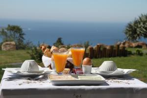 a table with food and two glasses of orange juice at Quinta Vale da Roca in Sintra