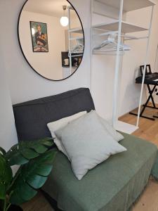 a mirror above a green couch with a pillow at Private Studio Central Vienna in Vienna +7 photos