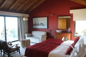 a bedroom with red walls and a bed and a chair at Quinta Vale da Roca in Sintra