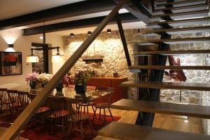 a dining room with a table and chairs and a stone wall at Quinta Vale da Roca in Sintra