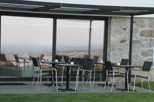 a group of tables and chairs on a balcony with windows at Quinta Vale da Roca in Sintra