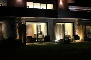 a house lit up at night with chairs and tables at Quinta Vale da Roca in Sintra