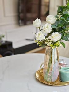 a vase filled with white roses on a table at Canary Pool Villa Bangsaen in Ban Hua Khao Sammuk