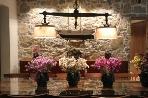 a table with vases of flowers on it with two lights at Quinta Vale da Roca in Sintra