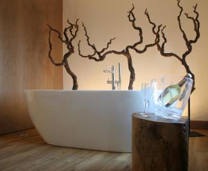 a bathroom with a white tub and a tree mural at Quinta Vale da Roca in Sintra