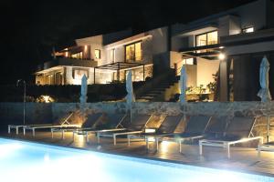 a group of chairs next to a swimming pool at night at Quinta Vale da Roca in Sintra