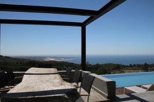 a dining table and chairs next to a swimming pool at Quinta Vale da Roca in Sintra