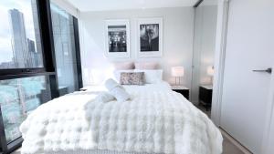 a white bedroom with a white bed and a window at Luxury apartment & free parking in Melbourne +28 photos