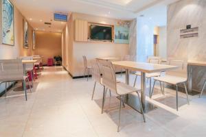 a restaurant with tables and chairs in a room at City Comfort Inn Wuhan Wansongyuan Wangjiadun East Metro in Wuhan