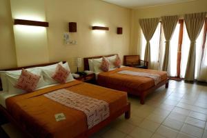 Dalumpinas OesteKahuna Beach Resort and Spa的一间酒店房间，房间里有两张床 更多62张照片