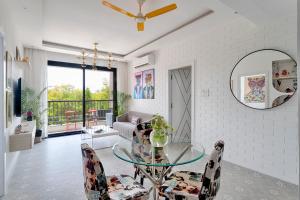 a living room with a glass table and a mirror at Happy Home by Leo Homes - 2BHK Flat in Candolim in Candolim