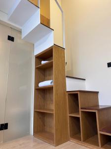 a staircase in a room with wooden shelves at Sienna Living Setiabudi in Jakarta +16 photos