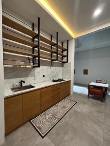 a large kitchen with a sink and a table at Sienna Living Setiabudi in Jakarta
