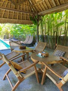 een terras met een tafel en stoelen en een zwembad bij SoulStar in Ubud