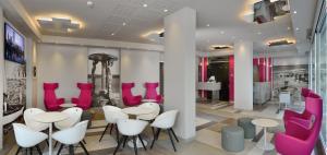 a salon with pink and white chairs and tables at Embassy Hotel & Spa in Cattolica