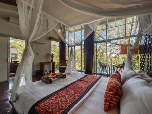 Un dormitorio con una cama grande en una habitación con ventanas. en Villa Kalisha - Romantic, Seclusion in the heart of Nature, en Tegalalang 27 fotos más