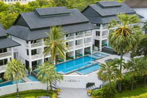 an aerial view of a house with a swimming pool and palm trees at Pullman Pattaya Hotel G in North Pattaya