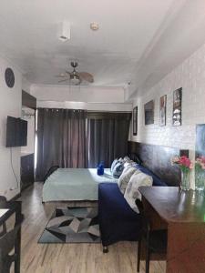 ein Schlafzimmer mit einem Bett, einer Couch und einem Tisch in der Unterkunft Jewel Aubrey's Tagaytay Staycation-17th Floor in Iruhin + 6 Fotos