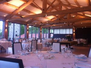 a banquet hall with white tables and chairs and glasses at Domaine Saint-Roch Hotel Spa in Salzuit