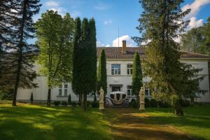 a white house with trees in front of it at Apple Manor & Garden Complex in Silajāni