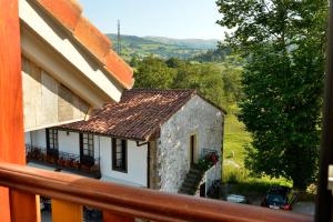 a small white building with a window and a balcony at Hotel La Alfonsina in Santibáñez de Villacarriedo
