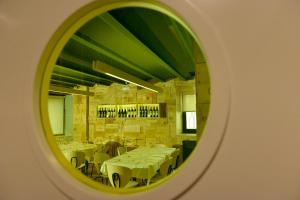 a mirror reflecting a dining room with white tables at Hotel La Alfonsina in Santibáñez de Villacarriedo