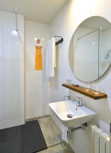 a white bathroom with a sink and a mirror at Hotel La Alfonsina in Santibáñez de Villacarriedo