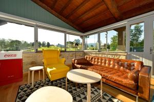 a living room with a couch and a chair and tables at Hotel La Alfonsina in Santibáñez de Villacarriedo