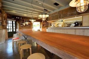 a large wooden bar in a restaurant with stools at Hotel La Alfonsina in Santibáñez de Villacarriedo