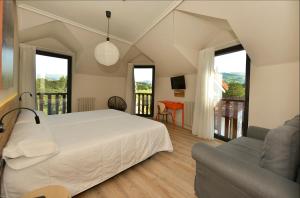 a bedroom with a bed and a balcony at Hotel La Alfonsina in Santibáñez de Villacarriedo