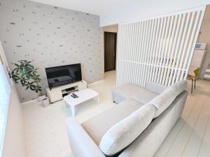 a living room with a couch and a tv at Vacation House 3 in Funabashi