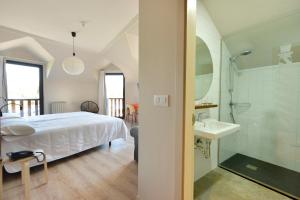 a bedroom with a bed and a sink and a bathroom at Hotel La Alfonsina in Santibáñez de Villacarriedo