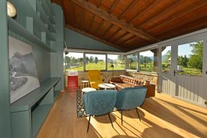 a screened in porch with chairs and a couch at Hotel La Alfonsina in Santibáñez de Villacarriedo