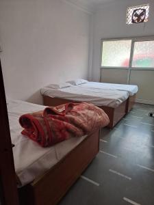 a room with two beds and a window at Hotel Narmada Puram in Indore