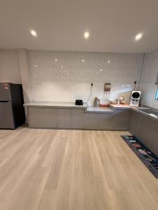 a large kitchen with a wooden floor in a room at Taman Bagan Homestay in Butterworth