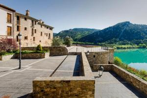 un bâtiment à côté d'un plan d'eau dans l'établissement Ligüerre Resort, à Ligüerre de Cinca