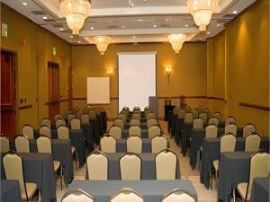 a conference room with chairs and a white screen at Garden Plaza Hotel in Saddle Brook +136 photos