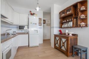 a kitchen with white cabinets and a white refrigerator at Paraíso Atlántico in Radazul